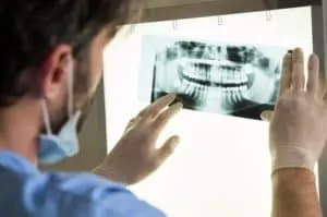male dentist examining dental x-ray